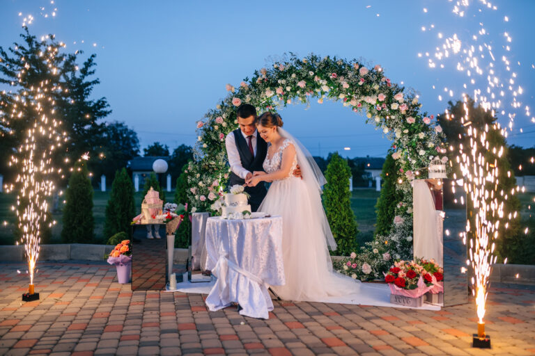 newlyweds-are-cutting-wedding-cake-dessert-wedding-table-night-lights